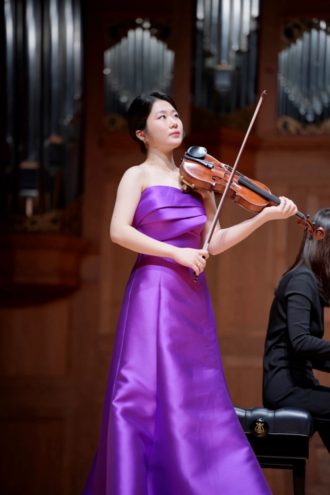 Byeol Kim standing with her violin during a live performance