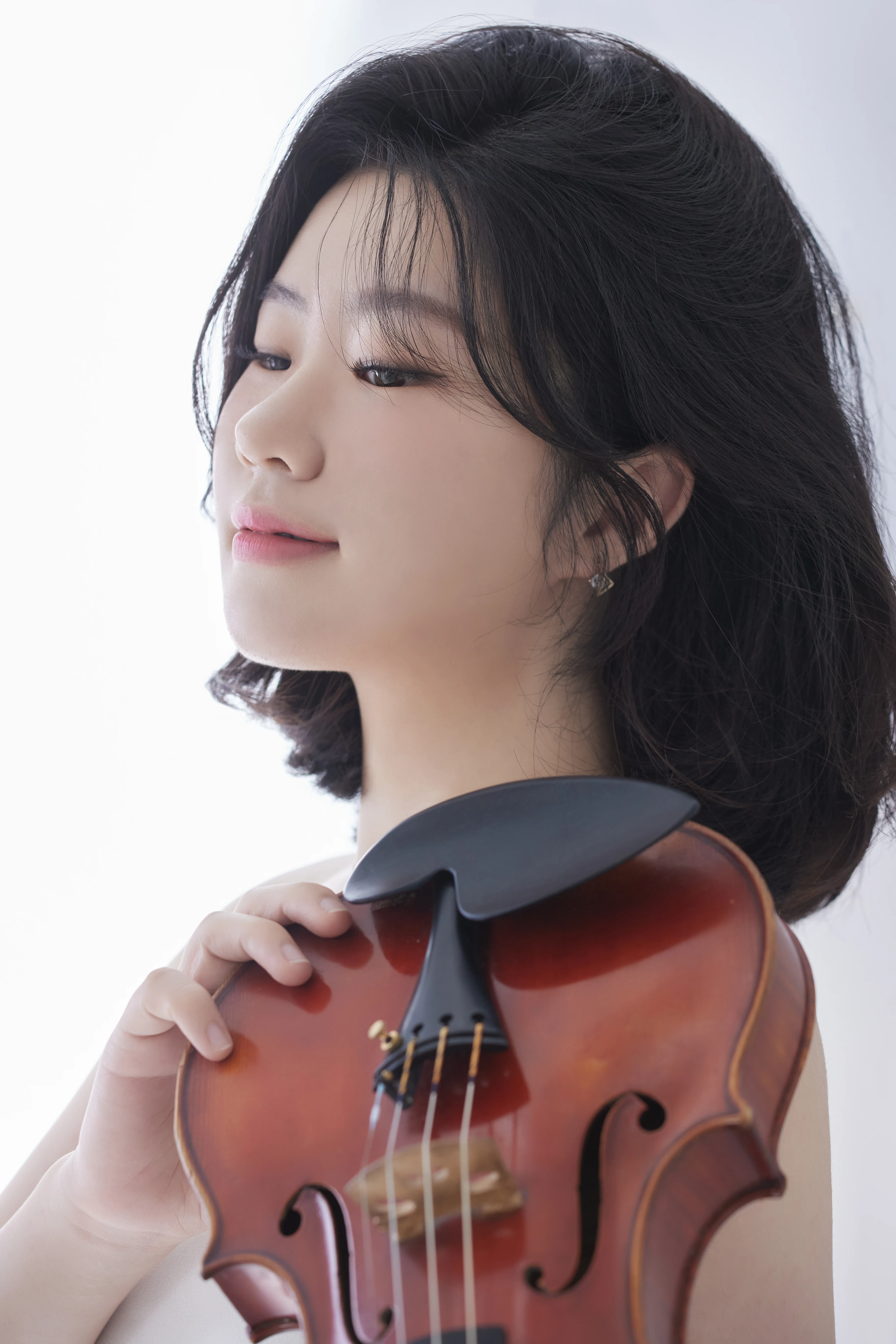 Close portrait of violinist Byeol Kim with her violin