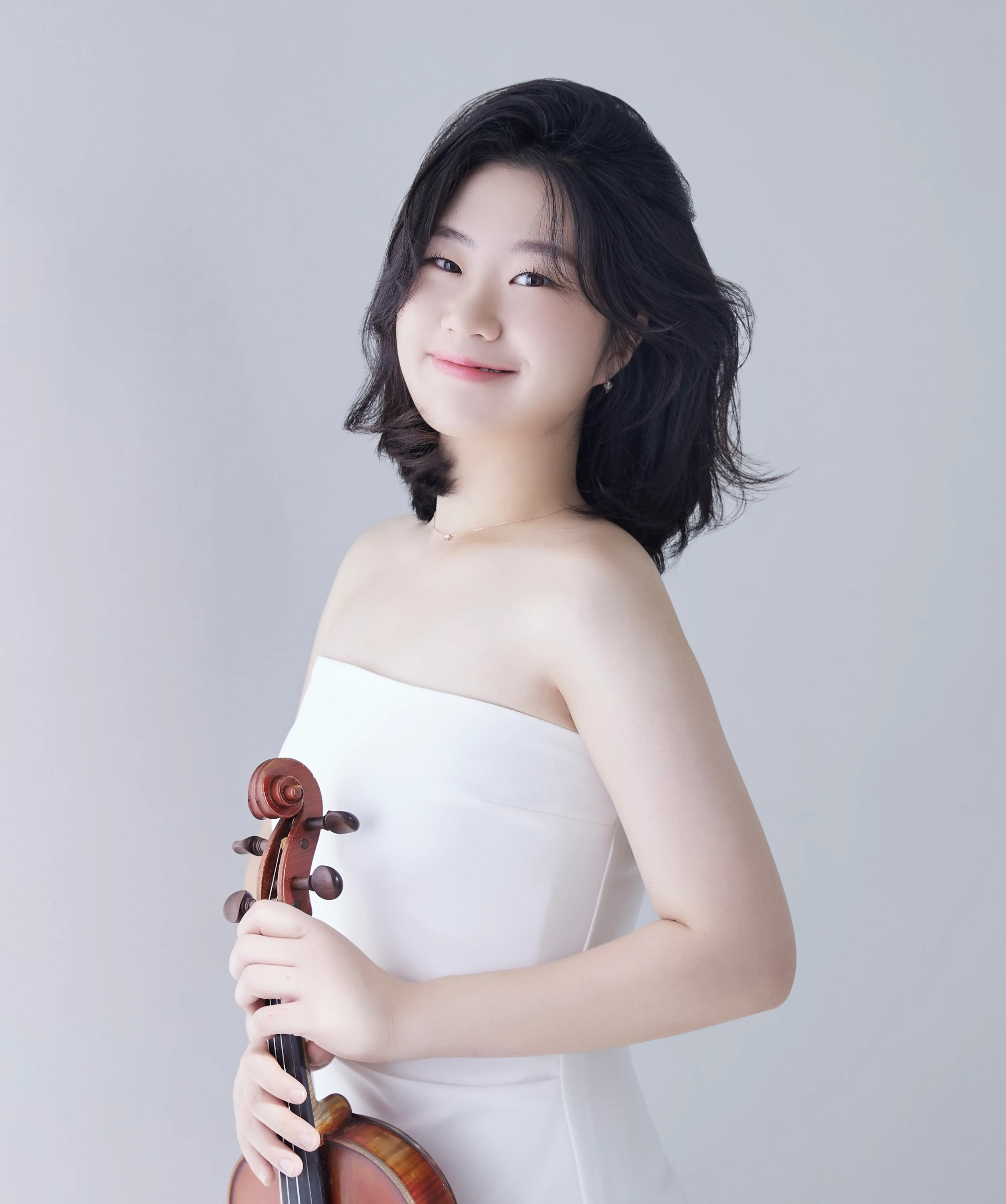 Portrait of violinist Byeol Kim in a white dress